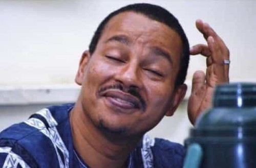 Gloating 01 Black, light skinned African looking guy, smiling w his finger scratching his head Embar.jpg