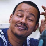 Gloating 01 Black, light skinned African looking guy, smiling w his finger scratching his head Embar