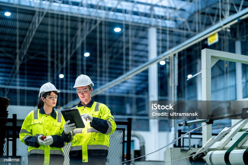 Male and female engineers in neat work clothes prepare and control the production system of large mo.jpg