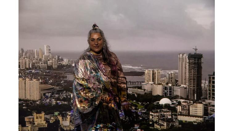 None Shaina Anand stands in front of the projection of Bombay Tilts Down displayed in the final room of the exhibit, Video After Video: The Critical Media of CAMP.