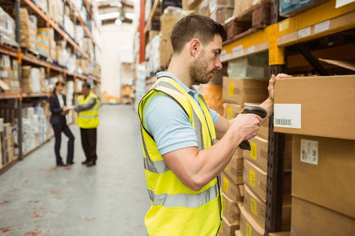 Warehouse worker scanning barcode on box in a large warehouse.jpg
