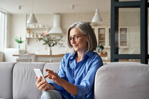 Relaxed mature old 60s woman, older middle aged female customer holding smartphone using mobile app,.jpg