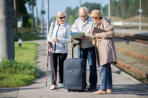 Group of positive senior people looking at map on traveling journey during pandemic.COVID-19 travel .jpg
