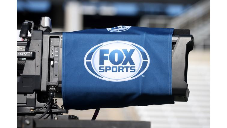 None And image of the Fox Sports logo on a broadcast camera lens.
