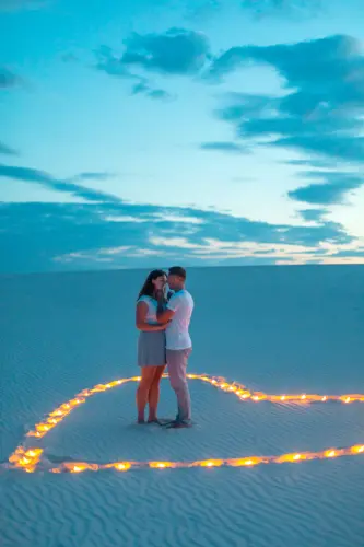 couple love romantic hugs sand desert evening romantic atmosphere sand burn candles form heart 10575.webp