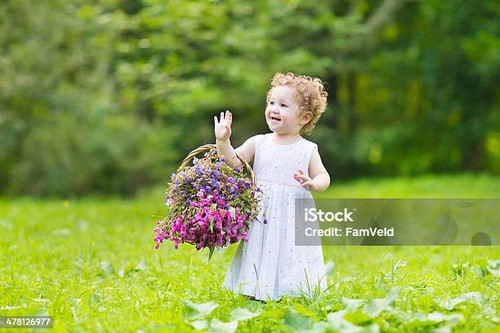 beautiful baby curly hair girl playing with flower basket.jpg