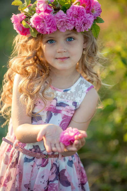 smiling baby 3 4 year old standing with basket of flowers outdoors looking at camera summer.jpg