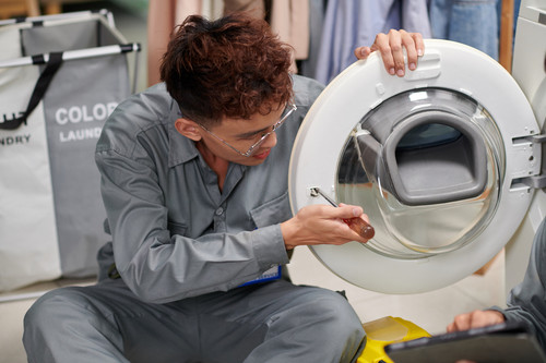 Repairman fixing broken washing machine door.jpg