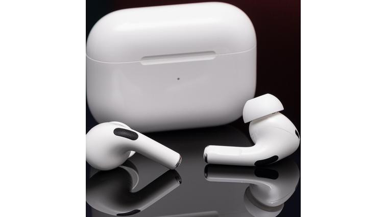 None Apple’s second-generation AirPods Pro photographed on a reflective black surface.