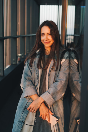 Portrait of a young attractive emotional girl dressed in a trendy blue denim coat, look at the camer.jpg