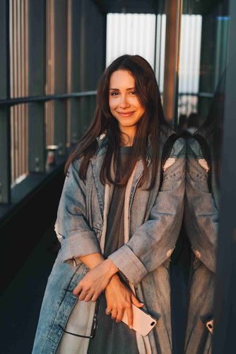 Portrait of a young attractive emotional girl dressed in a trendy blue denim coat, look at the camer.jpg