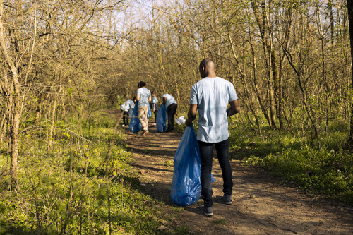 African american volunteer collecting garbage for community service, contributing to litter cleanup .jpg