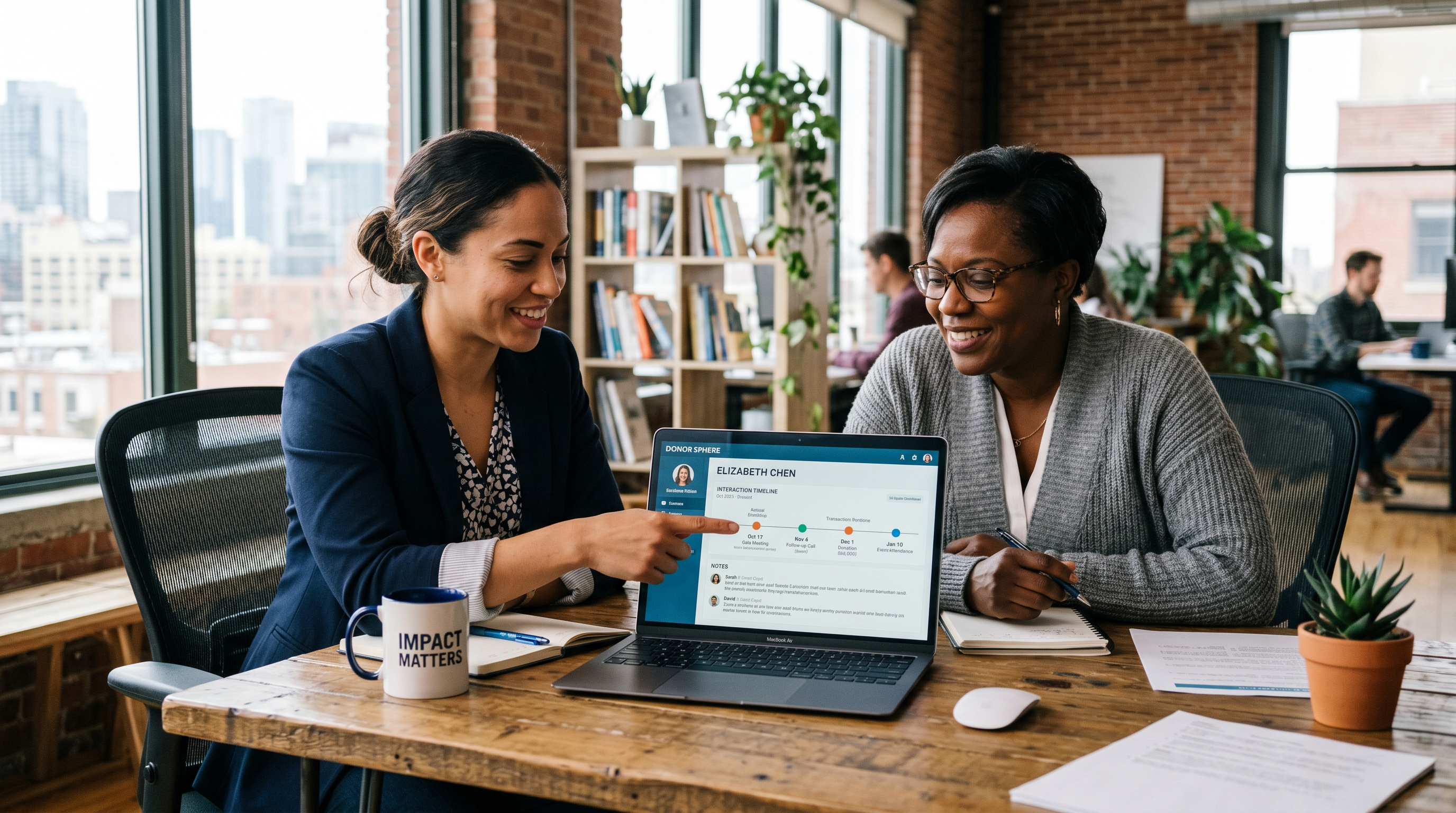 Two nonprofit staff members reviewing a donor interaction timeline together on a laptop