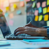 Business developer using Kanban board framework on laptop computer. Agile software development lean 