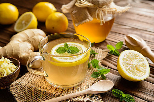 Cup of ginger root tea with lemon, honey and mint on a wooden background.jpg