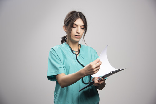 female doctor looking notes clipboard.jpg