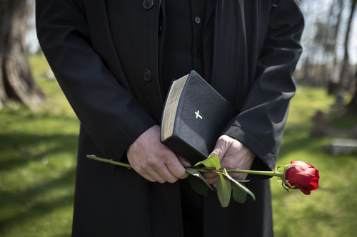 man holding flowers bible cemetry.jpg