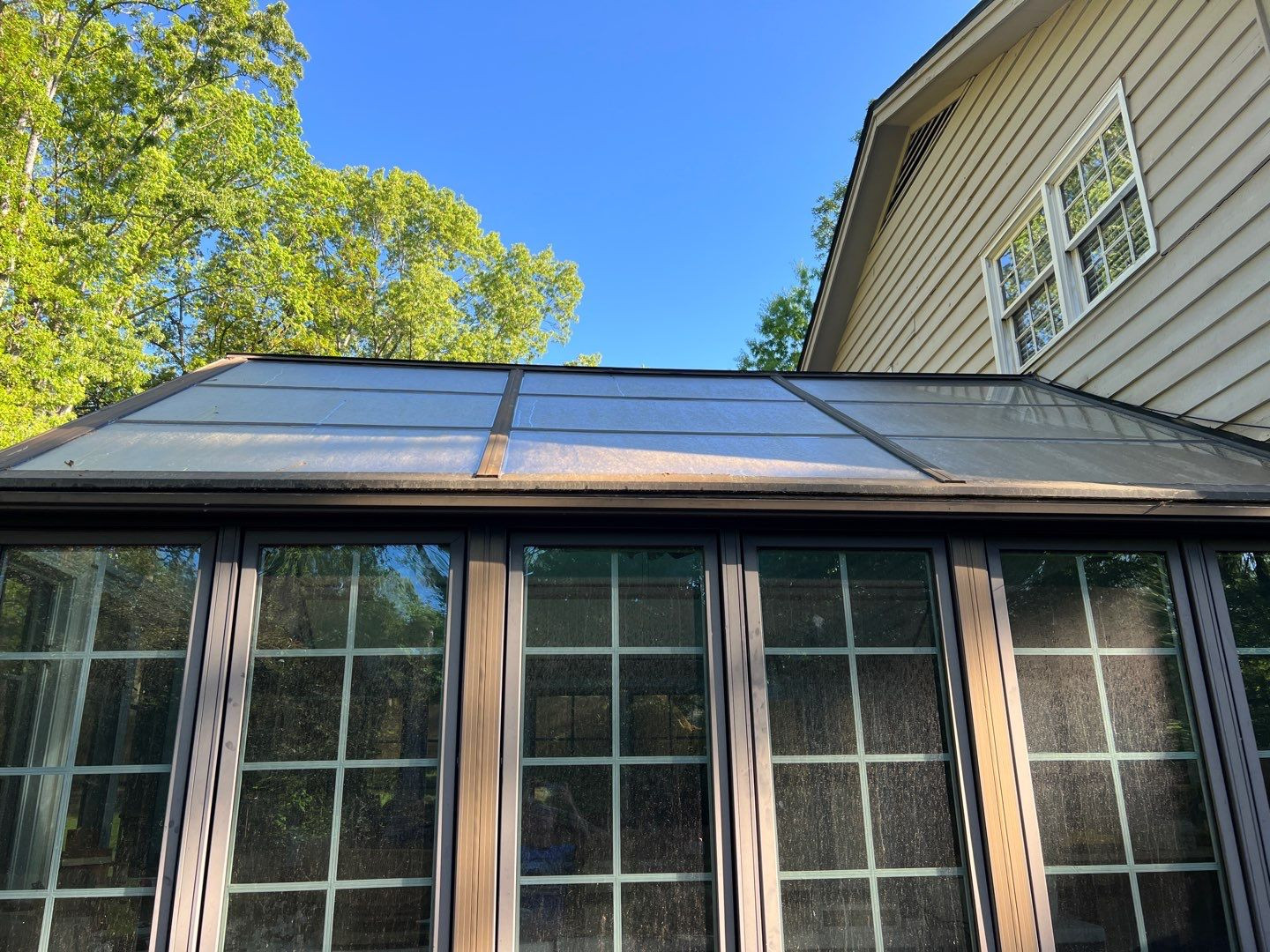 Dirty windows covered in pollen and hard water spots before professional cleaning