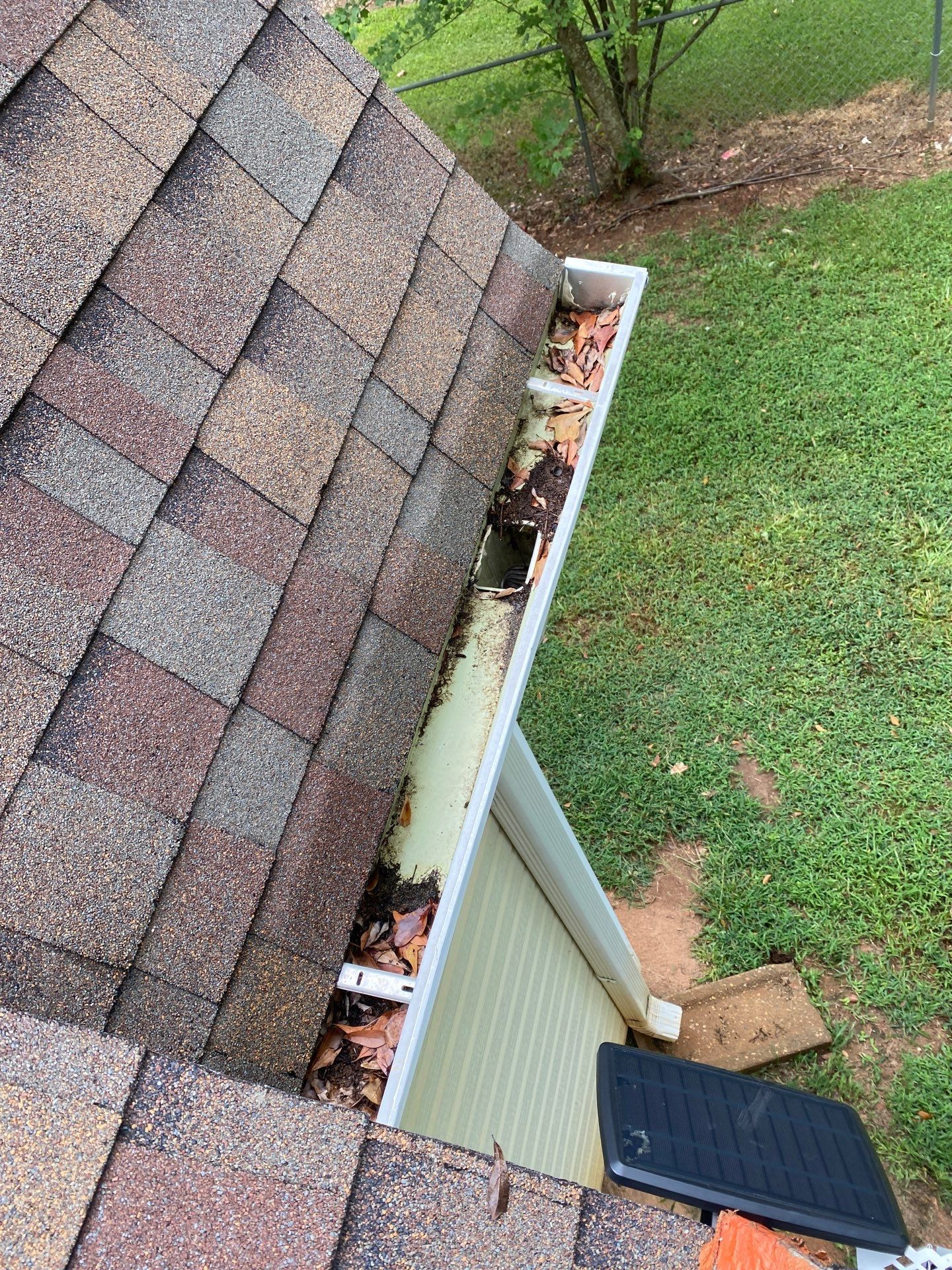 Clogged gutters full of debris before cleaning on a Commerce Georgia home