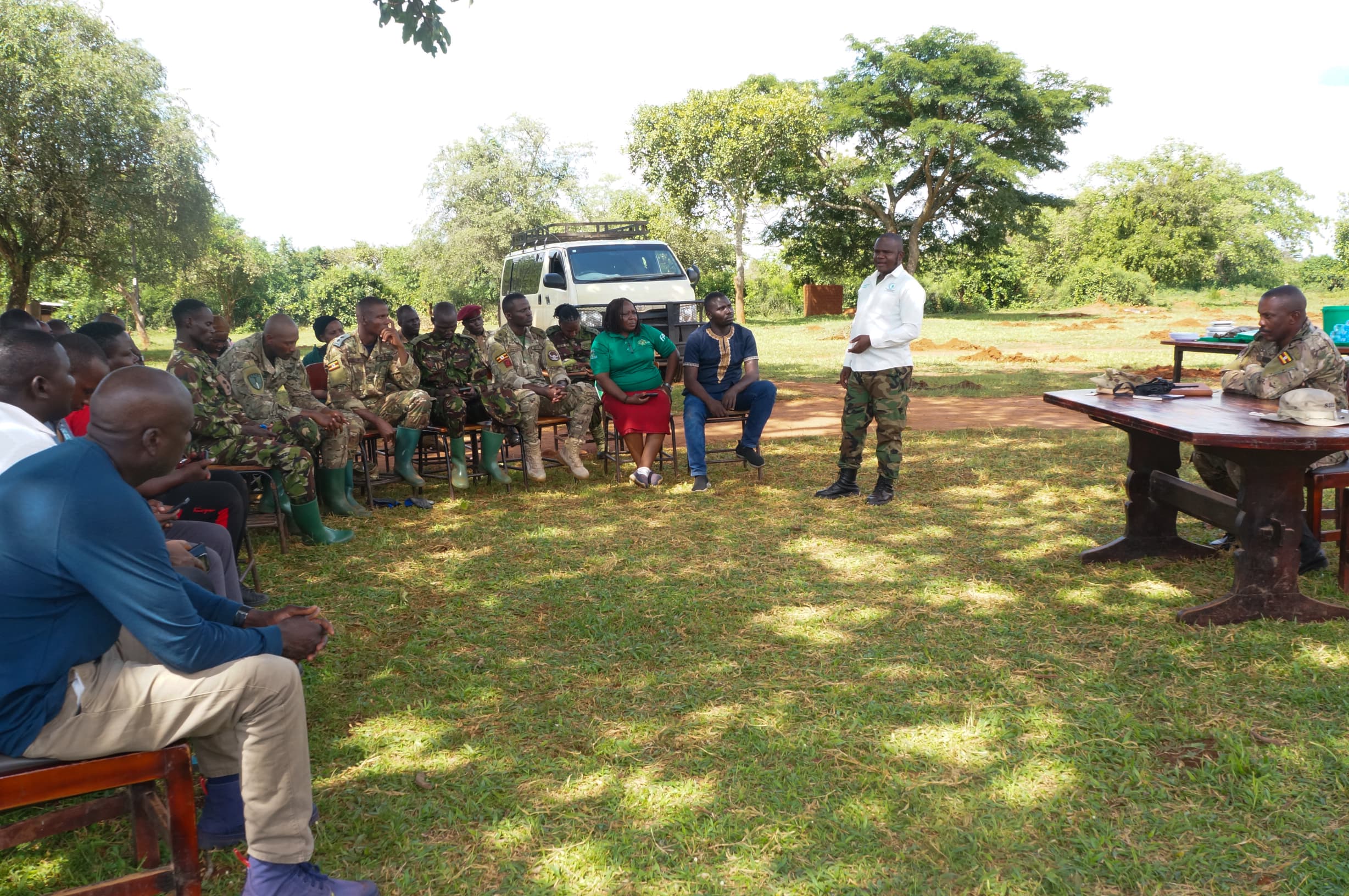 Dr. Jibril Semakura Owomugisha, the event cordinator (in white), speaking to soldiers in Kaweweta.