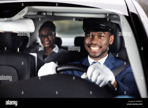 businesswoman sitting behind happy african male chauffeur driving car RFDPHH.jpg