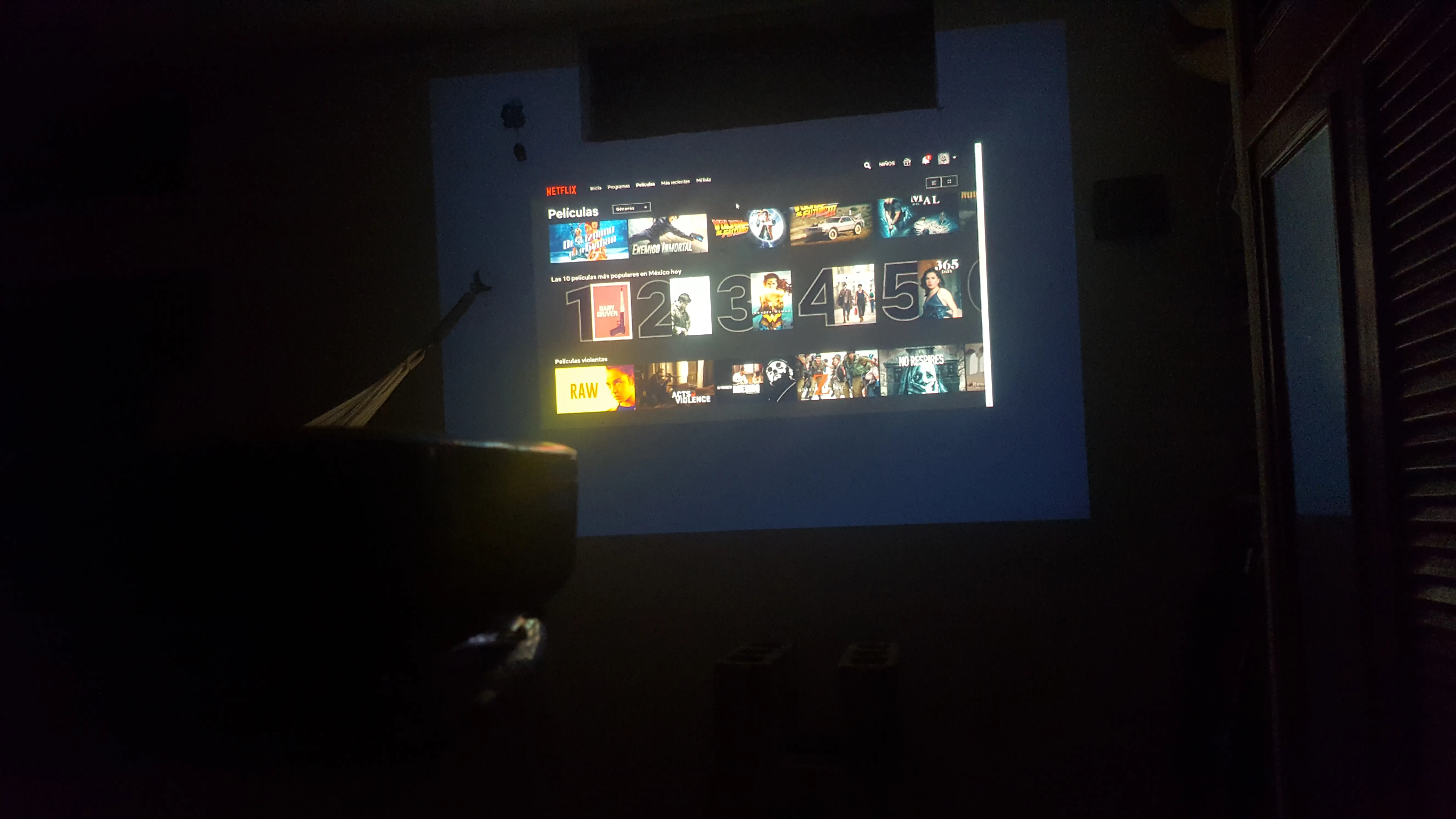 Pantalla inicial de Netflix proyectada en la pared de una habitación a oscuras