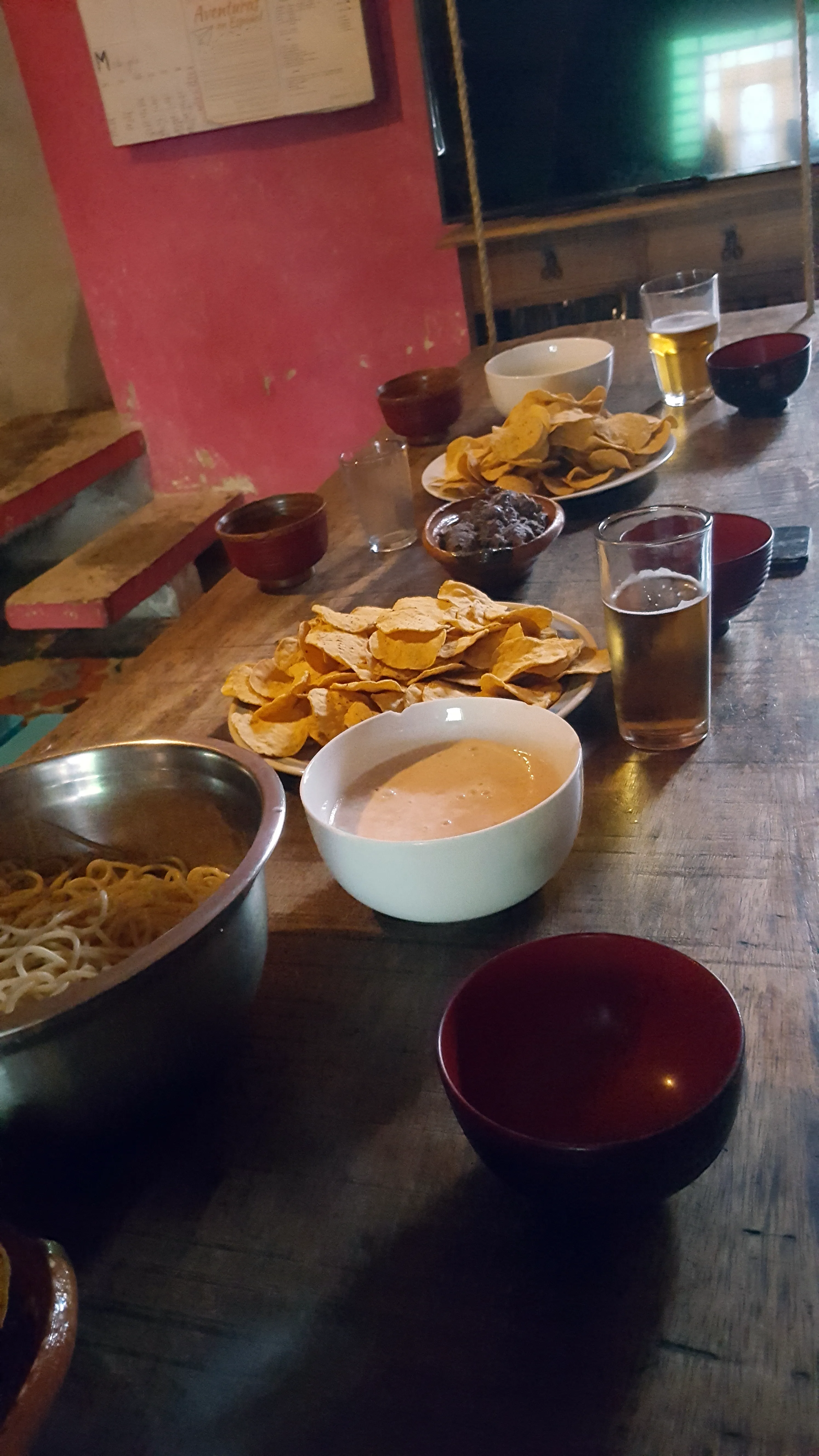 Mesa servida con diferentes platillos botaneros y un par de vasos de cerveza