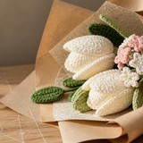 miniature white crochet tulip in kraft paper close up