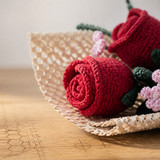 miniature red crochet rose in honeycomb paper close up