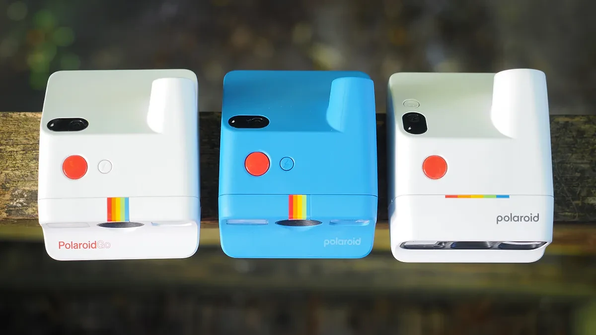 Top-down view of the Polaroid Go, Gen 2 and Gen 3 sitting on a wooden surface outdoors.