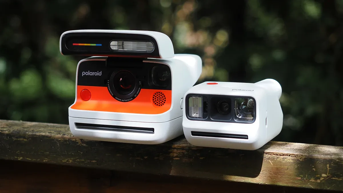 Polaroid Flip next to a Polaroid Go Gen 3 on a wooden surface, outdoors
