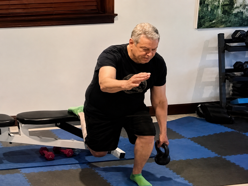 Homefit in-home personal training session using a kettlebell and lunge pattern in a home gym setting