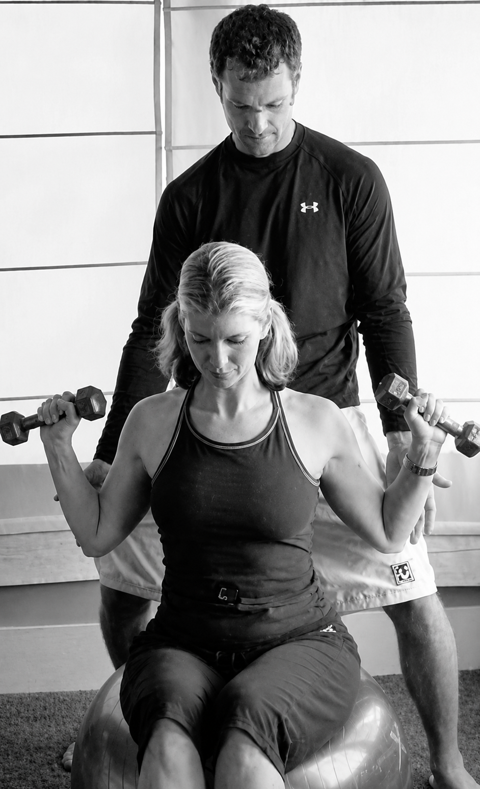Stewart McDonald coaching a client through a dumbbell shoulder press during a Homefit in-home personal training session