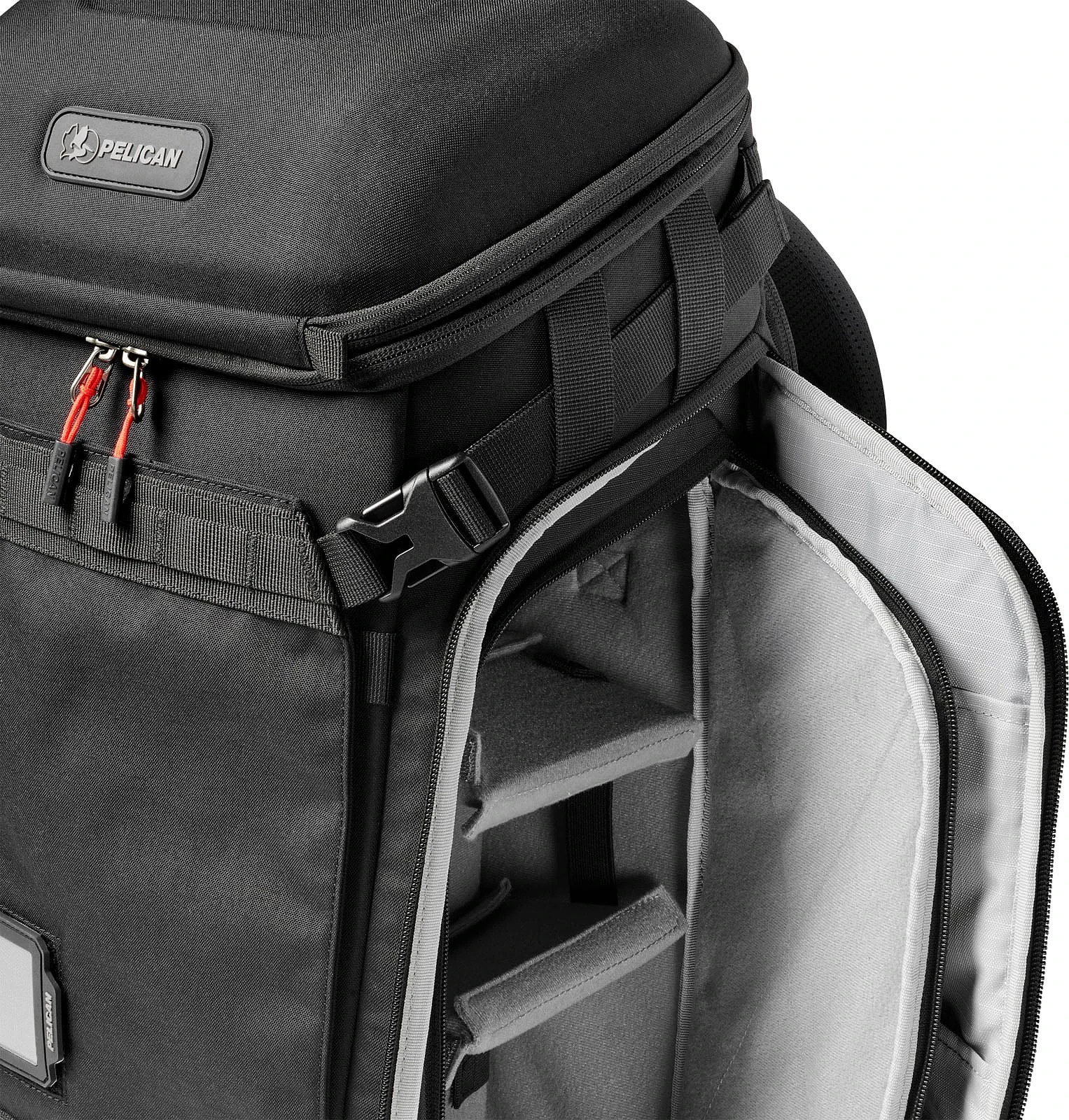 A black Pelican backpack with a side compartment open, revealing grey padded interior dividers and a zippered pocket on the inner flap.
