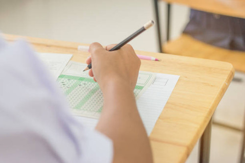 Students concentration holding pencils in hand doing multiple-choice quizzes testing exams answer sh.jpg