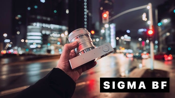 Máy ảnh Sigma BF màu đen với ống kính lớn, đặt trên một bề mặt, toát lên vẻ chuyên nghiệp.