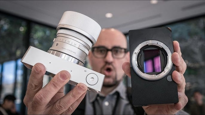 Máy ảnh Sigma BF thân máy màu đen với ống kính, đặt trên bề mặt tối.