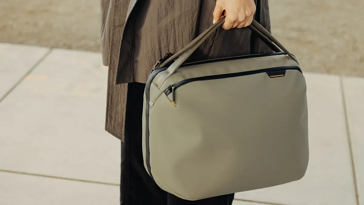 Hand holding Peak Design Travel Weekender 25L, a duffel-style bag