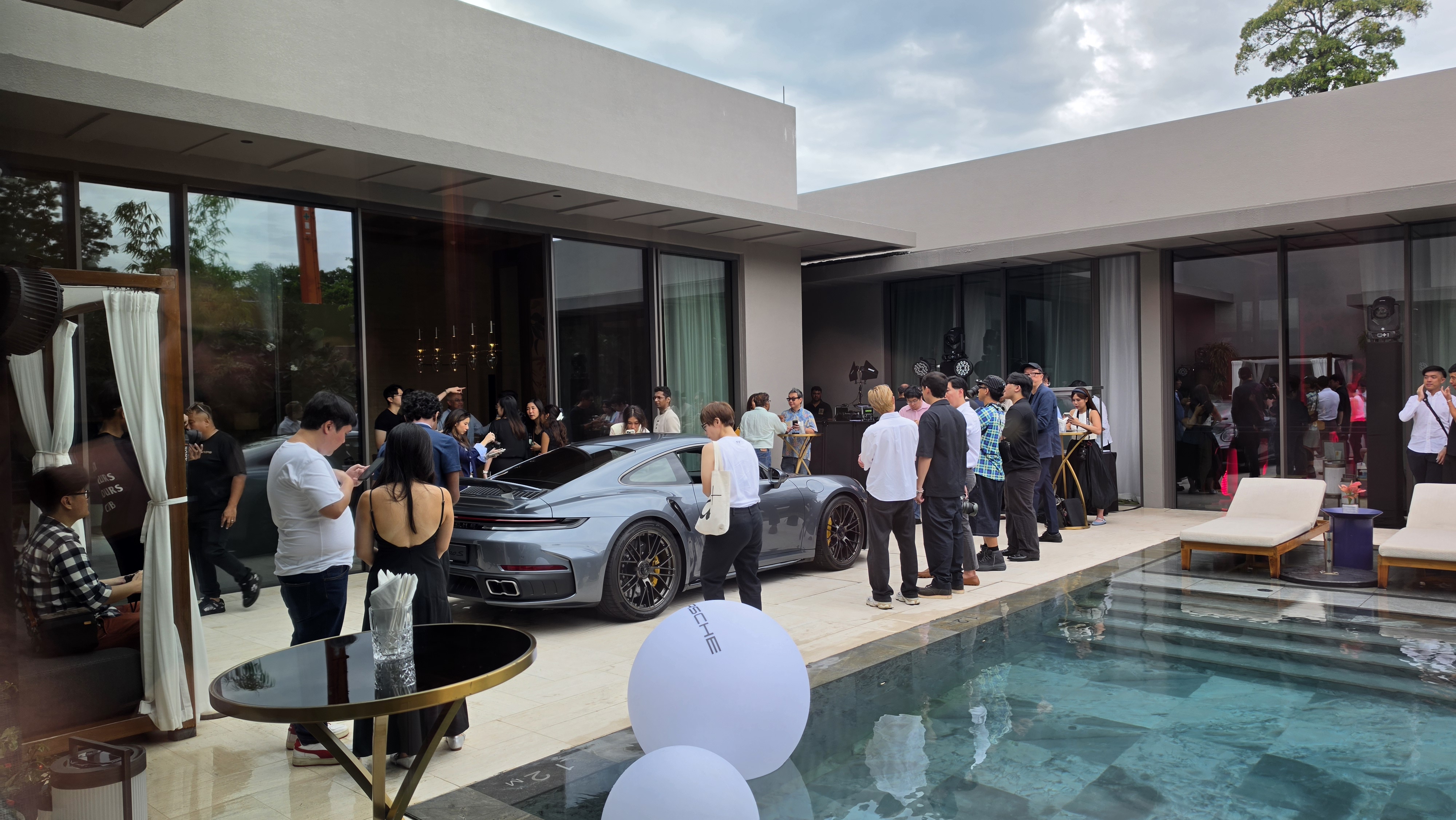 Guests admiring the rear of the Porsche 911 Turbo S