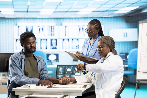 Physician measuring the heart rate of a young man by using her smartwatch, employing the digital fit.jpg