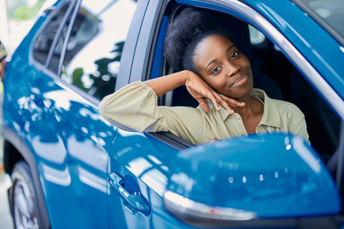 happy young black woman in dealership, beautiful lady came to buy automobile,she liked one of cars r.jpg