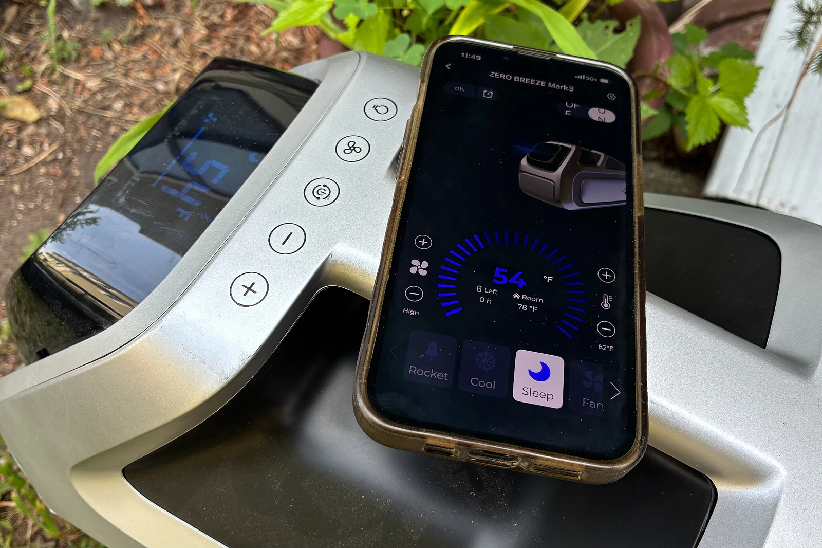 A smartphone resting on a portable AC unit, displaying the app that controls that AC.