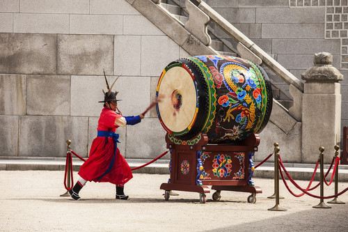 SEOUL, KOREA - APRIL 27, 2012: A guard is strking a giant ceremonial drum during the changing of the.jpg