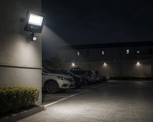 Esysense 20W IP65 motion sensor LED flood light illuminating a dark outdoor parking area.png