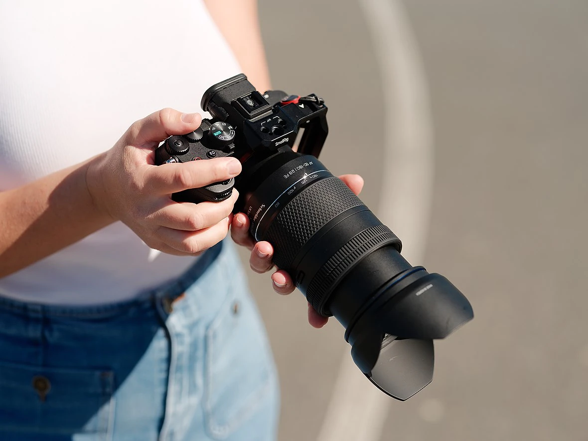 hands hold a camera with a lens extended