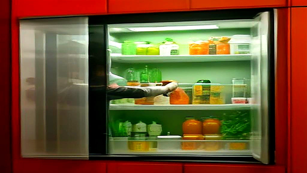 Kitchen manager checking shelves inside a multi-door glass merchandising freezer