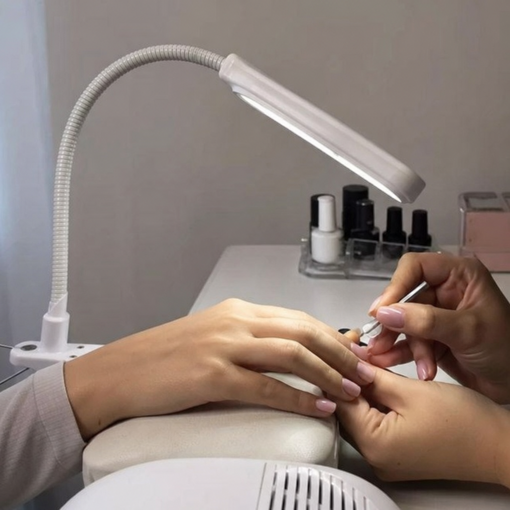 Flexibler Schwanenhals einer Maniküre-Tischlampe beim Ausleuchten eines Nagels