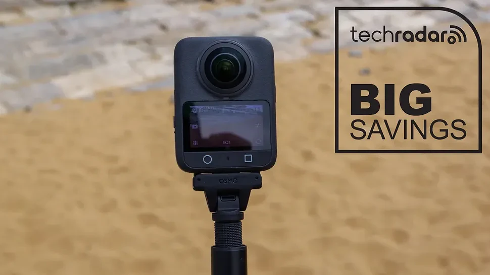 DJI Osmo 360 on a beach during our review, next to a TechRadar badge in black that reads 'Big Savings'