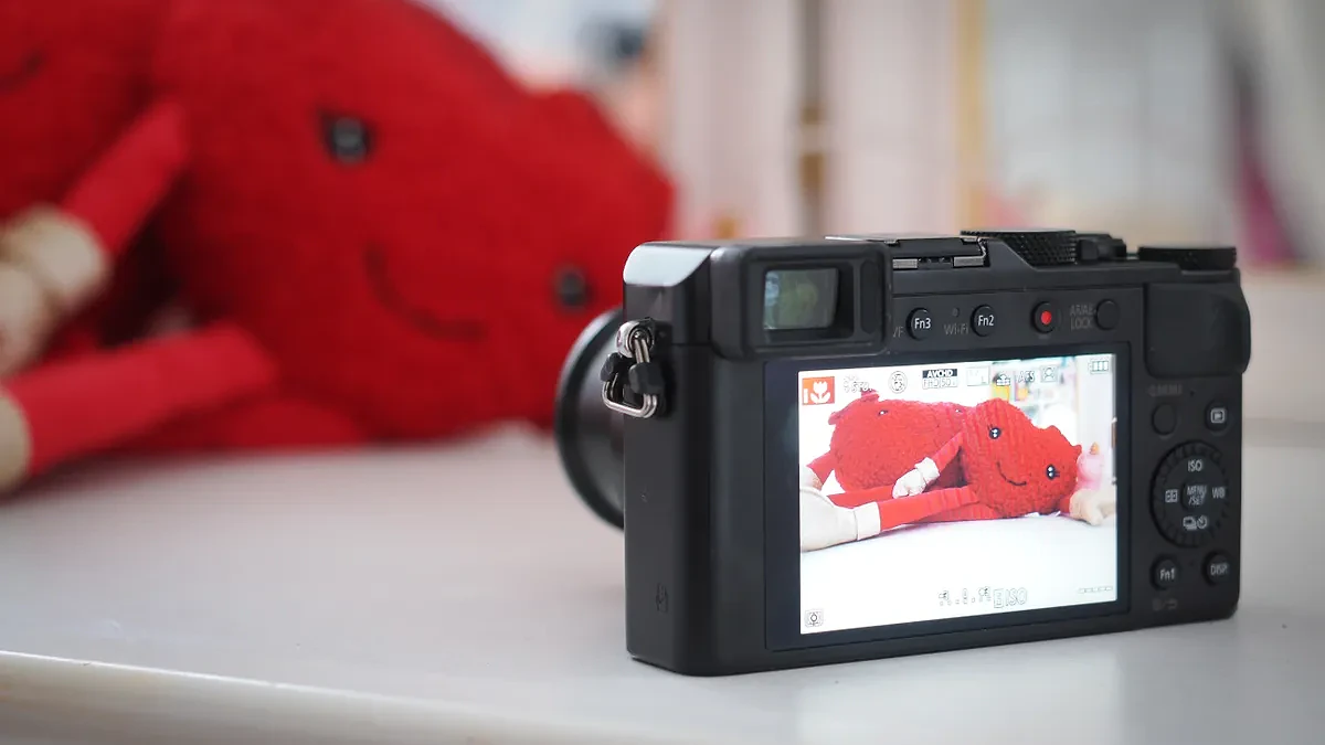 Panasonic Lumix LX100 on a table in front of plush toys