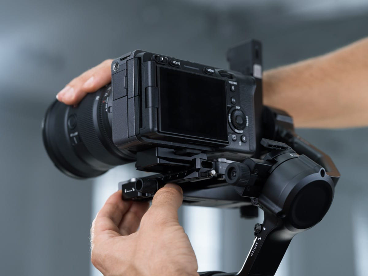Ảnh chụp cận cảnh người dùng thao tác với gimbal RS 5 và máy ảnh chuyên nghiệp